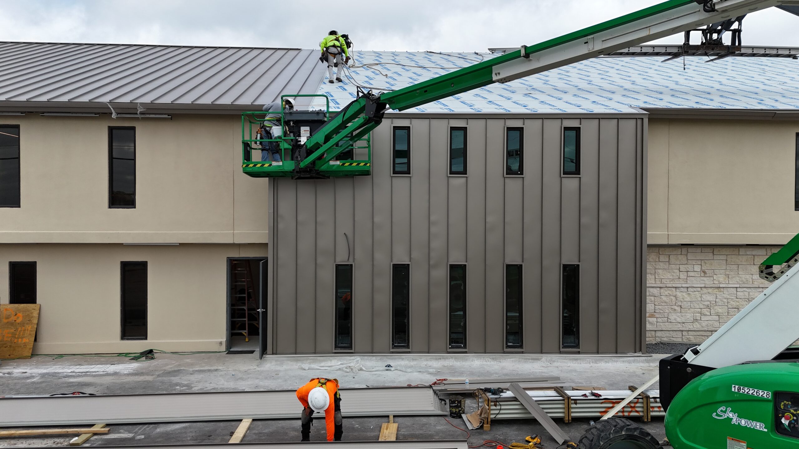 Workers installing a commercial standing seam metal roof for a Dallas, TX property.