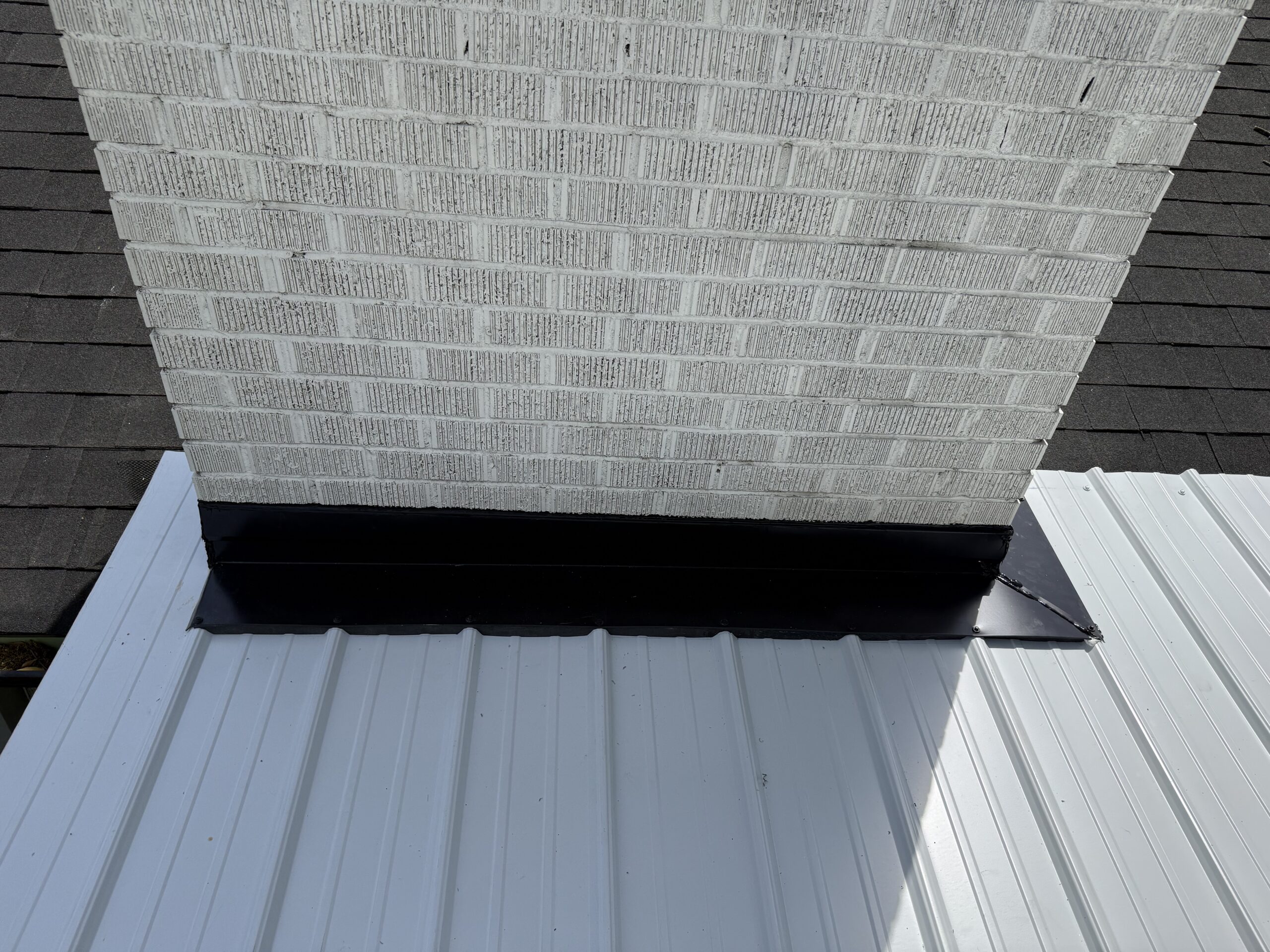 Professional chimney flashing and standing seam metal roofing installation for a residential home.