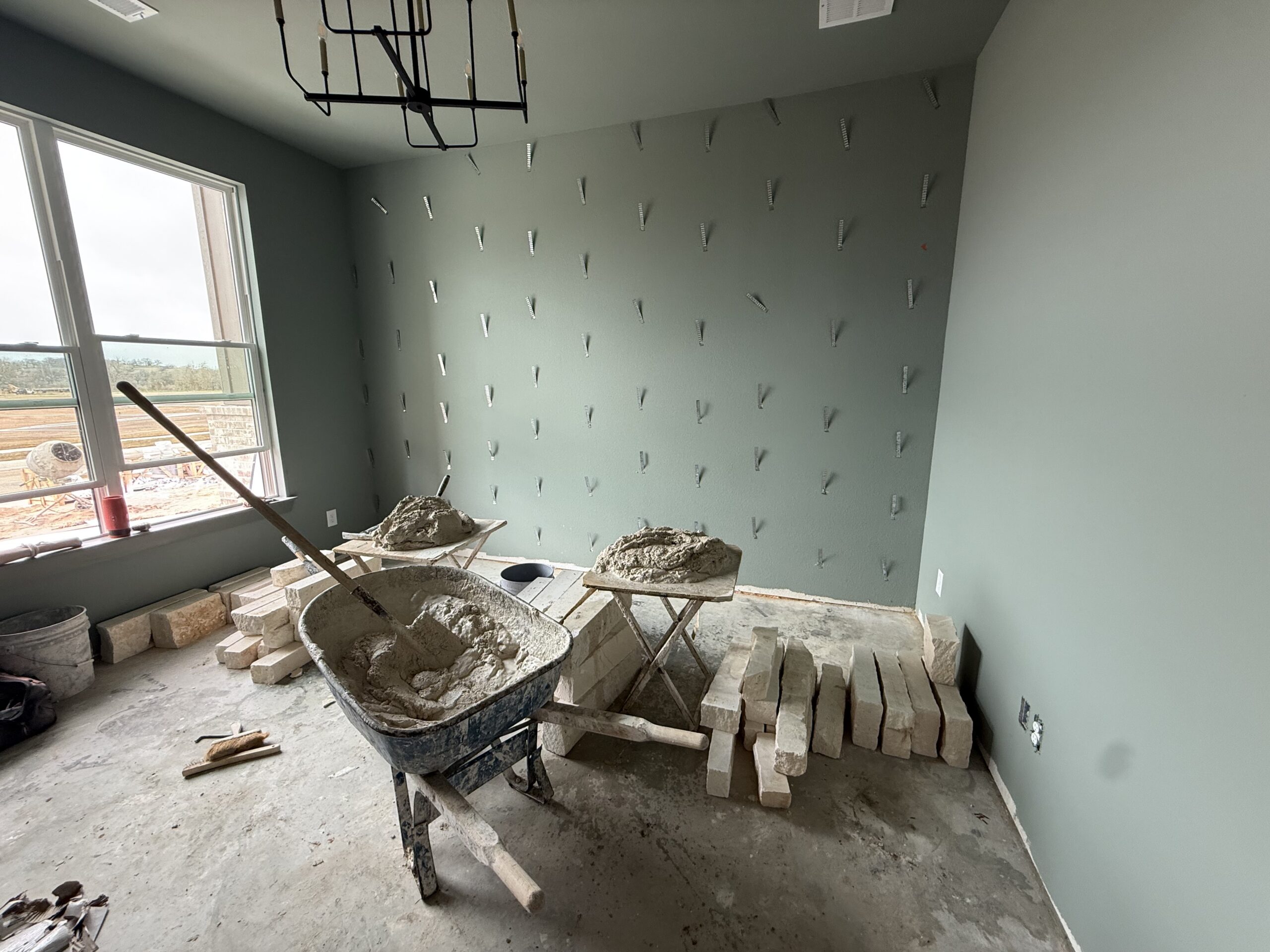 Interior stone accent wall under construction by Monarch Texas Contracting LLC.